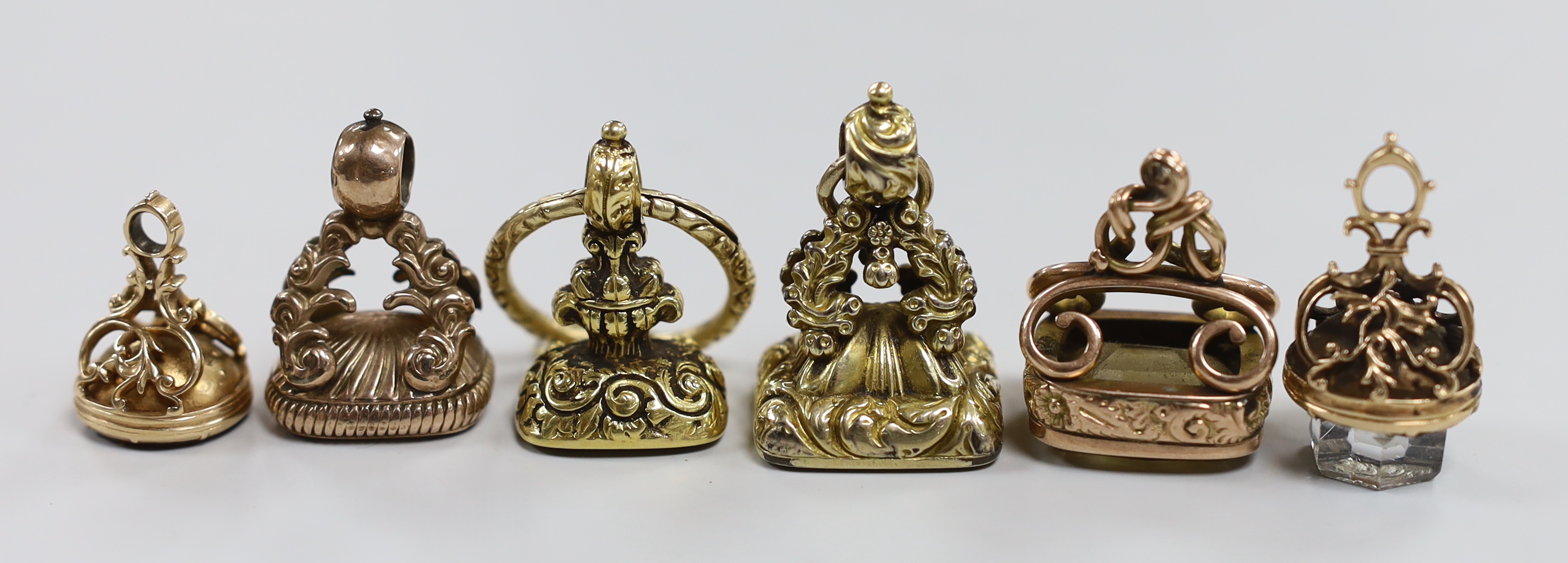 Six assorted 19th century yellow metal overlaid and carnelian or quartz set fob seals, largest 34mm, one matrix carved with armorial.